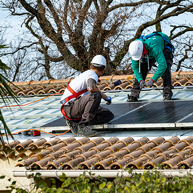 Pose de panneaux solaires sur toiture en tuiles par des installateurs en harnais — installation photovoltaïque, sécurité chantier et autoconsommation
